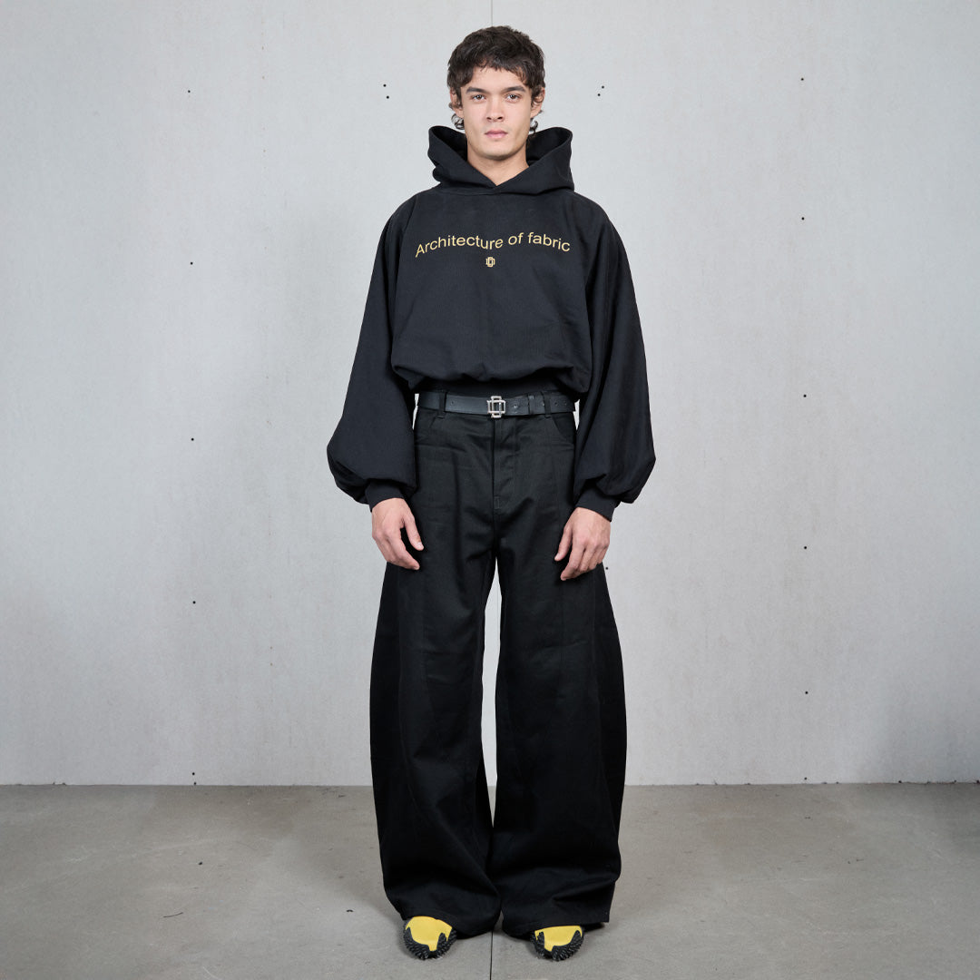 Sudadera con capucha negra, hombro caído y manga abullonada, con Architecture of Fabric bordado en el pecho