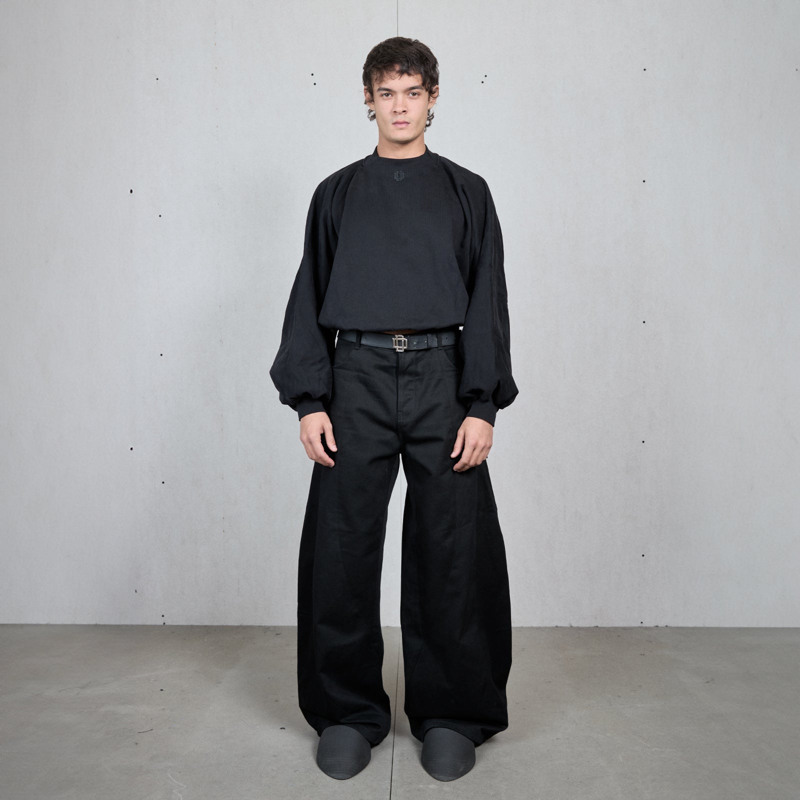 Sudadera negra de cuello redondo, hombro caído y manga abullonada